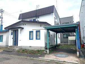 ein weißes Haus mit einem Schuppen davor in der Unterkunft Nagayama Home in Asahikawa