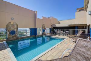 a swimming pool on the roof of a building at Slaviero Londrina Flat in Londrina