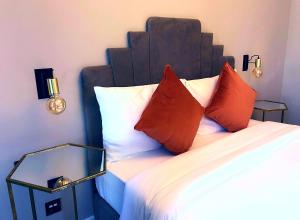 una camera da letto con un letto con cuscini rossi di Cinematique a Mosta