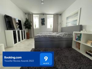 a bedroom with a bed and a tv in it at Barrierefrei - 24Std-CHECK-IN kontaktlos - Kingsize Bed - W-LAN - Parkplatz W 3 in Bückeburg +6 photos