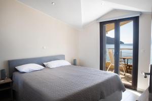 アギオス・ゲオルギオス・パゴンにあるBlue Heaven Apartmentsのベッドがあり海が見える寝室