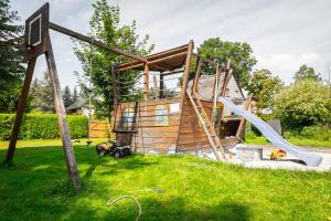 Spreewald Pension Tannenwinkel في لوبنو: منزل خشبي مع زحليقة في العشب