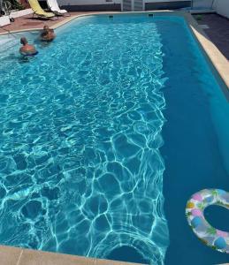 2 personas nadando en una piscina en Villa A'Mare en Seget Vranjica