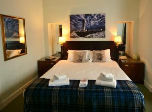 a bedroom with a bed with two towels on it at Corsewall Lighthouse Hotel in Kirkcolm