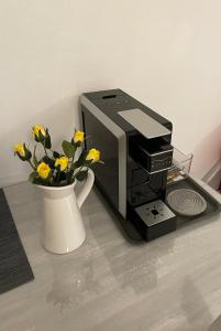 a coffee maker and a vase with yellow flowers at ALEKA KOTSI ROOMS 2 in Igoumenitsa