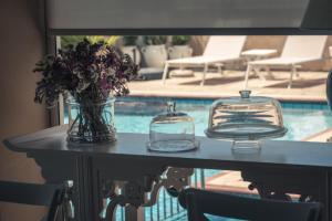 a table with two glass plates and a vase of flowers at Chrielka Hotel in Limassol