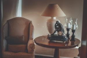 a lamp sitting on a table next to a chair at Chrielka Hotel in Limassol