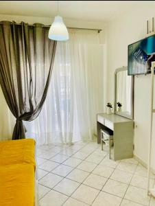 sala de estar con escritorio y TV en ALEKA KOTSI ROOMS 2, en Igoumenitsa