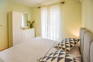 a bedroom with a bed and a dresser and a window at House Sun and Sea in Olib