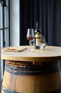 butelkę wina i szklankę na drewnianym stole w obiekcie Veltlin Bed & Wine w mieście Valtice