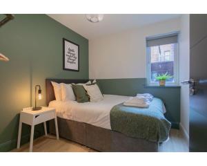 a bedroom with a bed and a table and a window at Central Belfast Apartments Camden Street in Belfast