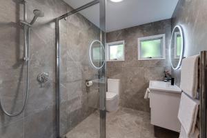 a bathroom with a shower and a toilet and a sink at Archway Motels & Chalets in Wanaka