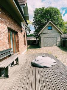 a dog bed on a deck next to a bench at Spacious family house in the city centre in Pāvilosta