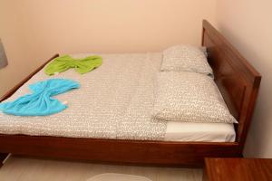Una pequeña cama de madera con 2 toallas. en Wilhelmina Hotel & Apartments en Paramaribo