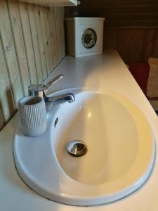 a white sink with a cup on top of it at Green vagon, farm b&b rooms for rent in Hjørring