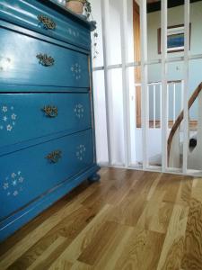 a blue dresser in a room with a wooden floor at Green vagon, farm b&b rooms for rent in Hjørring