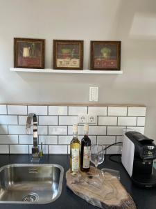 um balcão de cozinha com duas garrafas de vinho e um lavatório em ‘t Bakhuis em Oostelbeers