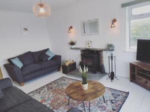 a living room with a couch and a table at Trevose, sea views in Port Isaac