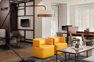 uma sala de estar com uma cadeira amarela e uma mesa em Hyatt Place Oklahoma City Bricktown em Oklahoma City