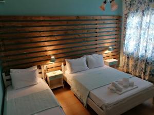 a bedroom with two beds and a wooden wall at Litsa's House Platanias in Agia Paraskevi