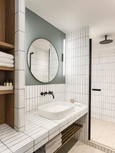 a bathroom with a tub and a mirror at Hôtel & Spa Belle Plage in Cannes
