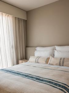 a bedroom with a large bed with a window at Hôtel & Spa Belle Plage in Cannes