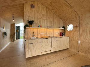 a kitchen with a sink and a wooden wall at Wikkelhuis 31- Pet Friendly in Stavoren
