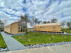 a large wooden building on a field with a grass yard at Wikkelhuis 31- Pet Friendly in Stavoren