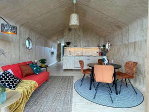 a living room with a red couch and a table at Wikkelhuis 31- dier vriendelijk in Stavoren