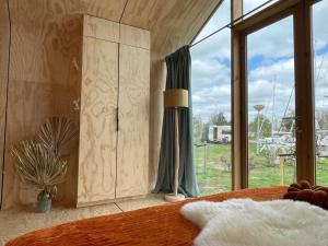 a bedroom with a bed and a large window at Wikkelhuis 31- Pet Friendly in Stavoren