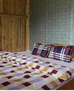 łóżko z kocem i 2 poduszkami w obiekcie Organic Farm Homestay w mieście Sa Pa