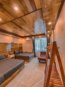1 dormitorio con 2 camas y techo de madera en Villa Đường Mây, en Tam Ðảo