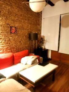 een woonkamer met een bank en een bakstenen muur bij 4 LOFT TEMPORAL EN CIUTAT VELlA in Valencia