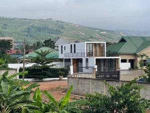 een wit huis met een heuvel op de achtergrond bij Xantis in Accra