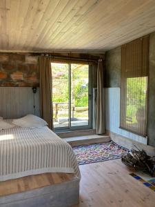 um quarto com uma cama e uma grande janela em Cabana do Dinamarquês em Arga de Baixo em Arga de Baixo