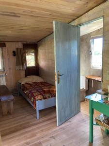 um quarto com uma cama num quarto com uma porta em Cabana do Dinamarquês em Arga de Baixo em Arga de Baixo