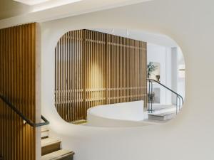 a bathroom with a round mirror and a sink at Hôtel & Spa Belle Plage in Cannes