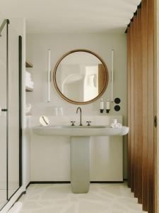 a bathroom with a sink and a mirror at Hôtel & Spa Belle Plage in Cannes