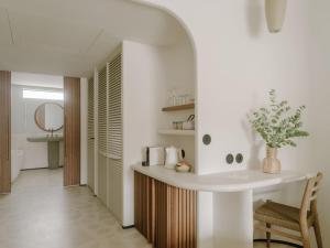 a white bathroom with a sink and a chair at Hôtel & Spa Belle Plage in Cannes
