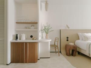 a bedroom with a bed and a table and a chair at Hôtel & Spa Belle Plage in Cannes