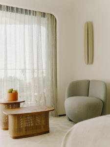 a bedroom with a bed and a chair and a window at Hôtel & Spa Belle Plage in Cannes