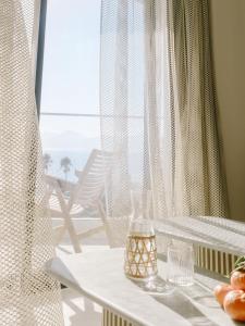 a glass vase sitting on a table with a window at Hôtel & Spa Belle Plage in Cannes