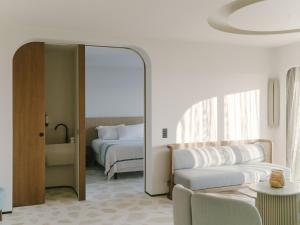 a bedroom with a mirror and a bed and a couch at Hôtel & Spa Belle Plage in Cannes