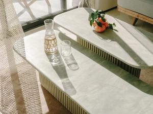 a table with two glasses and a vase on it at Hôtel & Spa Belle Plage in Cannes