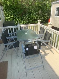 2 sillas y una mesa en una terraza en CLJP Caravan Thorpe Park Cleethorpes Free WI-FI, en Cleethorpes
