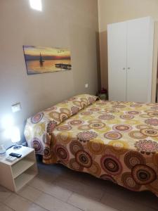 カステッランマーレ・デル・ゴルフォにあるAppartamenti La Stellaのベッドルーム1室(ベッド1台、テーブル、絵画付)