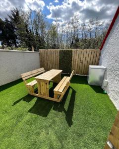 a picnic table and a bench on the grass at Glenside Cottage 'Sleeping 4 guests' in Buncrana