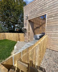 um edifício de madeira com uma cerca num quintal em Glenside Cottage 'Sleeping 4 guests' em Buncrana