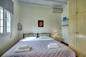 a bedroom with a bed with two towels on it at Beach Villa Athanasia - villa with private pool on the beach by PosarelliVillas in Acharavi +26 photos