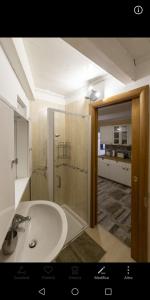 Un baño con lavabo y ducha de cristal. en Natiolum la casa vacanze a Giovinazzo, en Giovinazzo